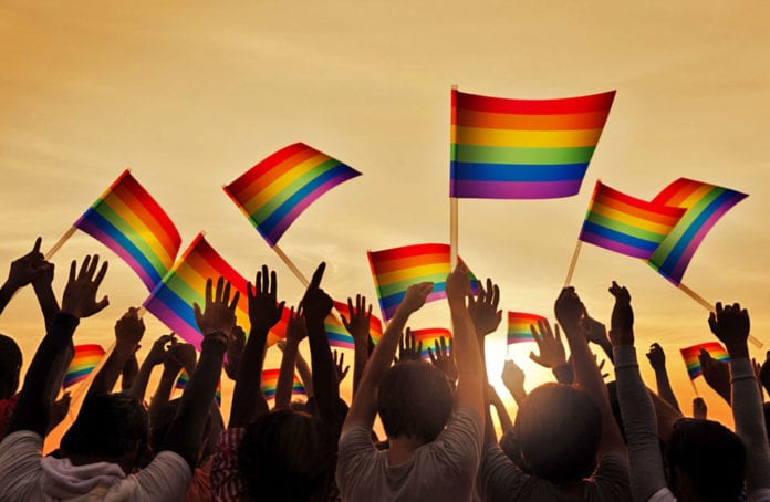 Silhouettes-People-Holding-Gay-Pride-Symbol-Flag